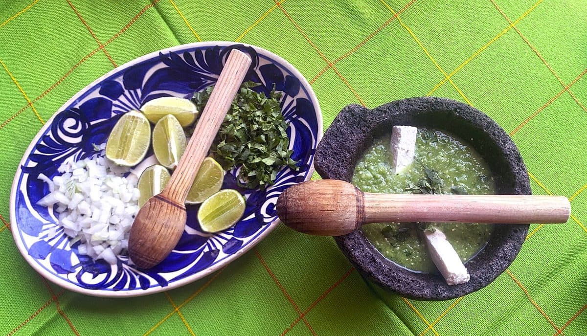 Salsa verde i en morter av stein, med lime, løk og koriander